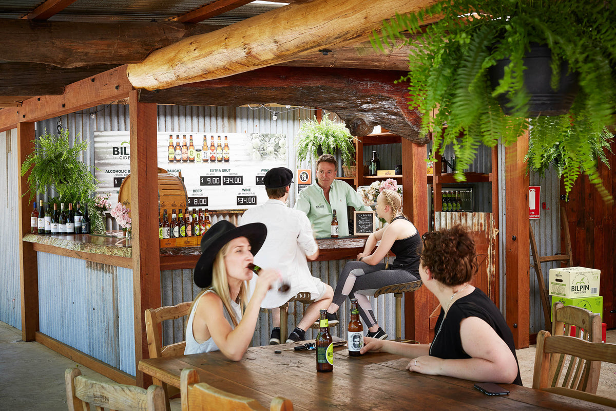 Visitors seated at Bilpin Cider’s timber cellar door bar